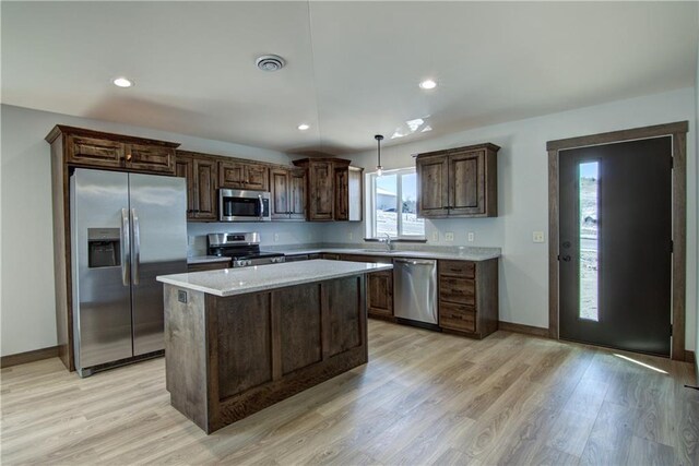1805 11th Ave Lot 19, Menomonie, WI 54751 - kitchen featuring stainless steel appliances, a sink, light countertops, dark brown cabinetry, and a center island