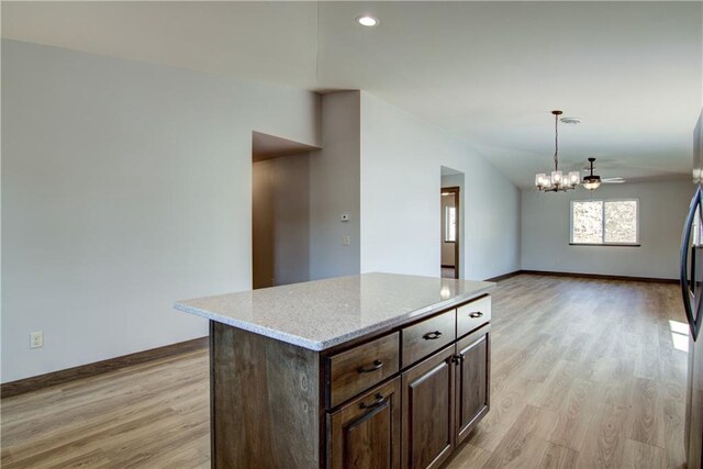 1805 11th Ave Lot 19, Menomonie, WI 54751 - kitchen featuring light wood finished floors, baseboards, a chandelier, dark brown cabinetry, and vaulted ceiling