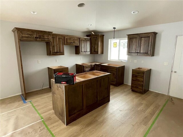 1805 11th Ave Lot 19, Menomonie, WI 54751 - kitchen featuring a center island, light wood-style flooring, hanging light fixtures, dark brown cabinetry, and recessed lighting