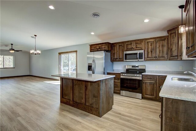 1805 11th Ave Lot 19, Menomonie, WI 54751 - kitchen with stainless steel appliances, a sink, light wood finished floors, a kitchen island, and pendant lighting
