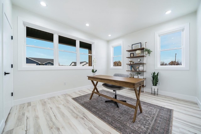 office space featuring plenty of natural light and light hardwood / wood-style flooring