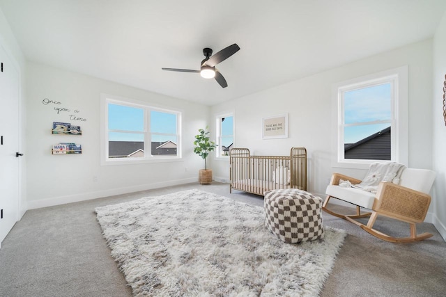 bedroom featuring a crib, carpet floors, and ceiling fan