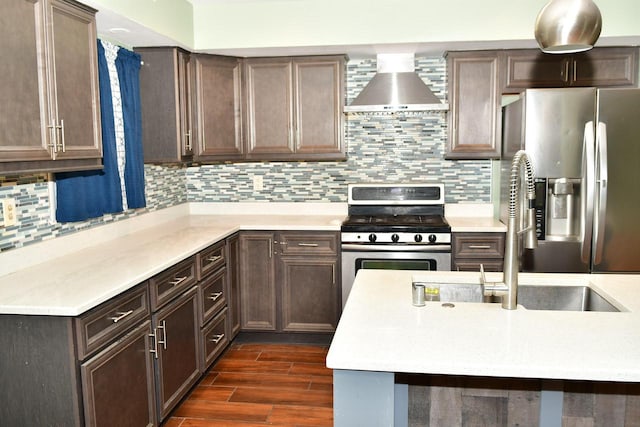 kitchen featuring stainless steel appliances, dark hardwood / wood-style flooring, decorative backsplash, dark brown cabinetry, and wall chimney exhaust hood