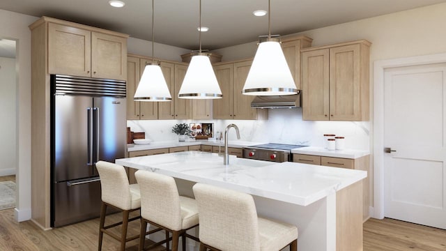 1718 N River Cir, River Hills, WI 53217 - kitchen featuring stainless steel built in fridge, light brown cabinets, light wood finished floors, a kitchen island with sink, and recessed lighting