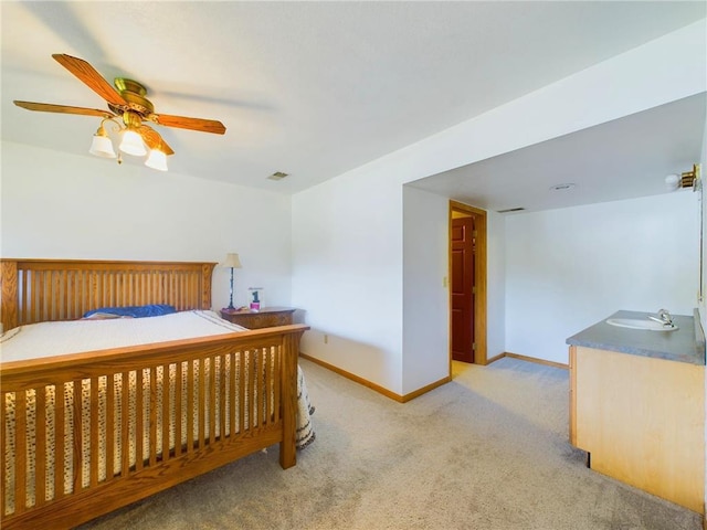 carpeted bedroom featuring ceiling fan and sink