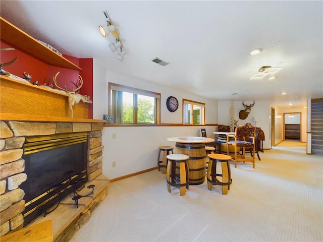 dining area featuring a fireplace, light colored carpet, and track lighting