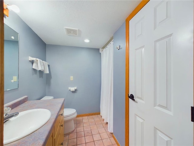 bathroom with vanity, tile patterned flooring, and toilet