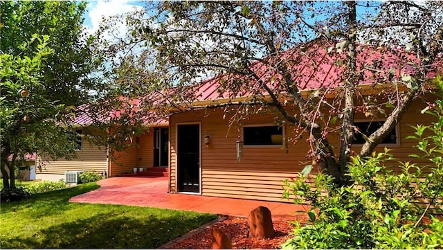 rear view of property featuring a yard, cooling unit, and a patio