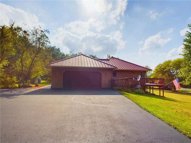 view of front of home featuring a garage, a front yard, and a deck