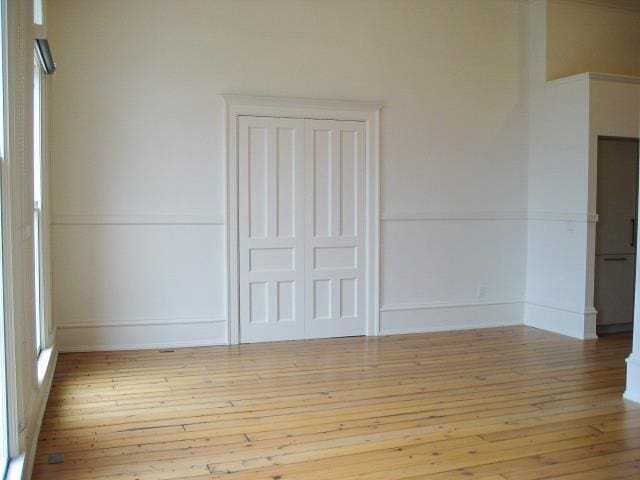 spare room featuring wood-type flooring and baseboards