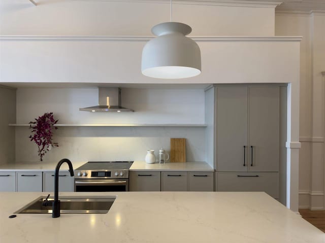 kitchen featuring sink, wall chimney exhaust hood, light stone counters, stainless steel electric range, and gray cabinets