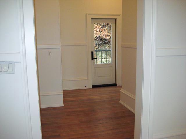 corridor featuring wood finished floors and baseboards