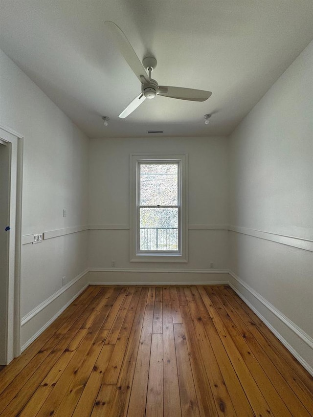 spare room featuring hardwood / wood-style flooring, baseboards, and a ceiling fan