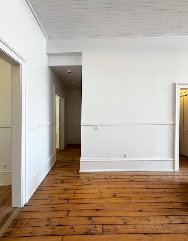 unfurnished room featuring wood-type flooring and ornamental molding