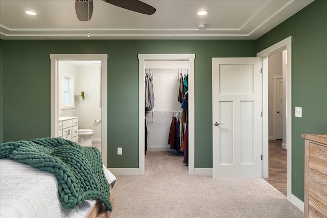 carpeted bedroom featuring ensuite bath and ceiling fan