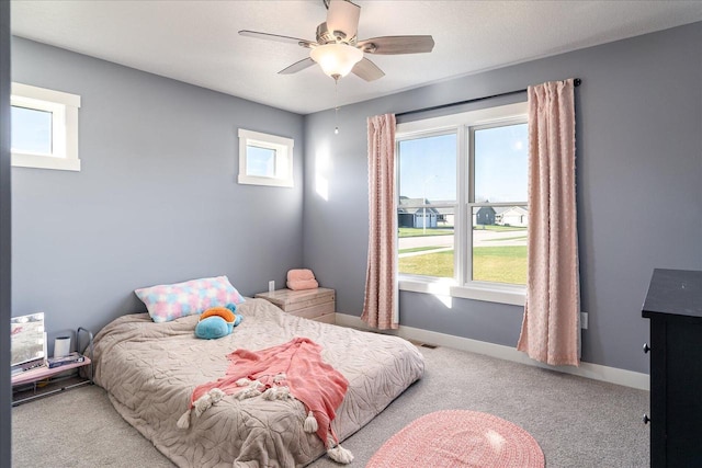 carpeted bedroom with multiple windows and ceiling fan