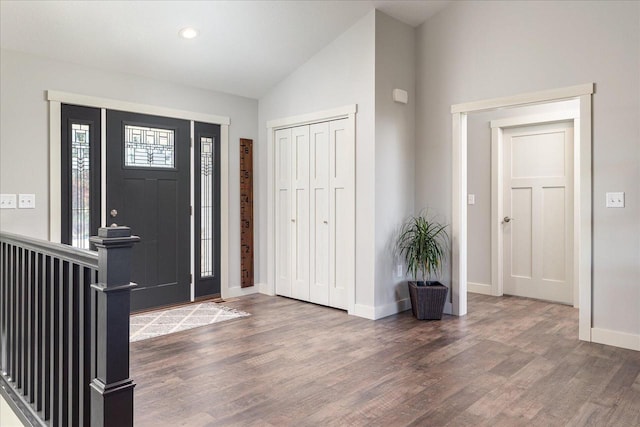 entrance foyer featuring dark wood-type flooring and vaulted ceiling