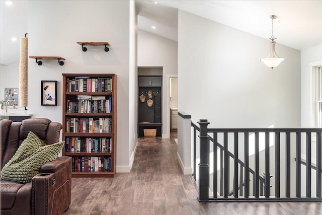 corridor featuring wood-type flooring, sink, and high vaulted ceiling