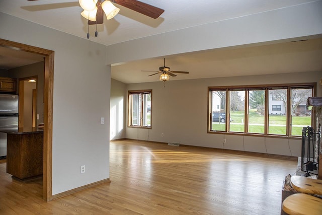 unfurnished living room featuring light wood-type flooring and ceiling fan