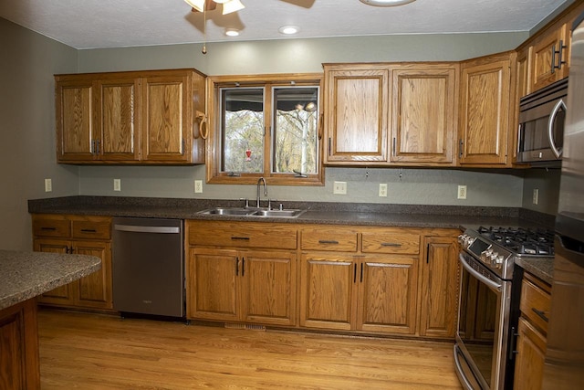 kitchen with ceiling fan, light hardwood / wood-style floors, sink, and stainless steel appliances