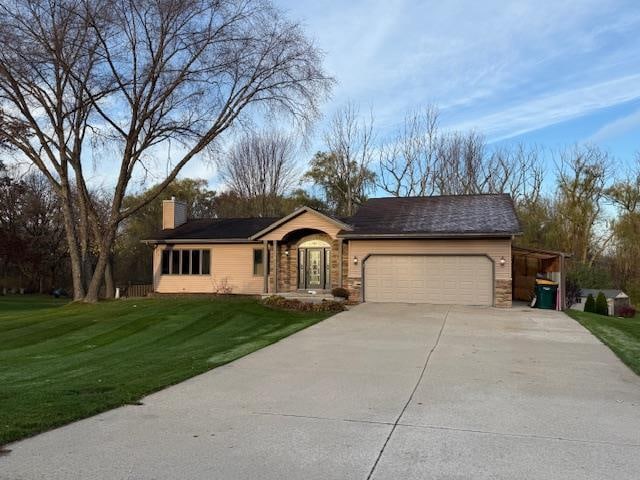 ranch-style house featuring a garage and a front lawn