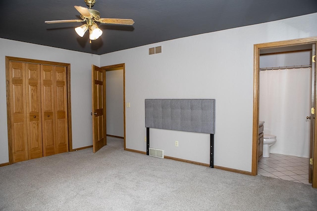 unfurnished bedroom with light carpet, connected bathroom, and ceiling fan