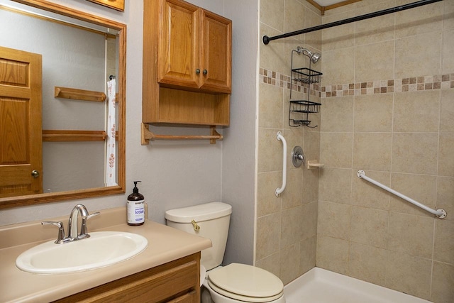 bathroom featuring vanity, toilet, and tiled shower