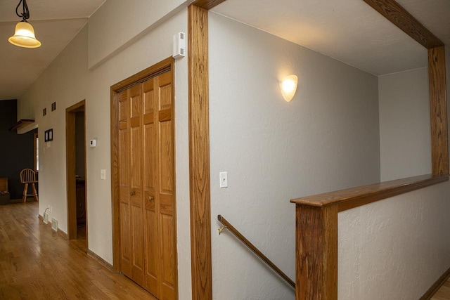 hallway featuring hardwood / wood-style floors and lofted ceiling