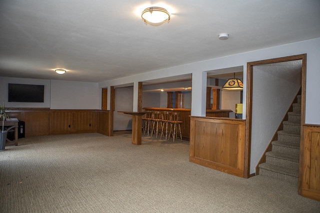 basement featuring light carpet and bar area