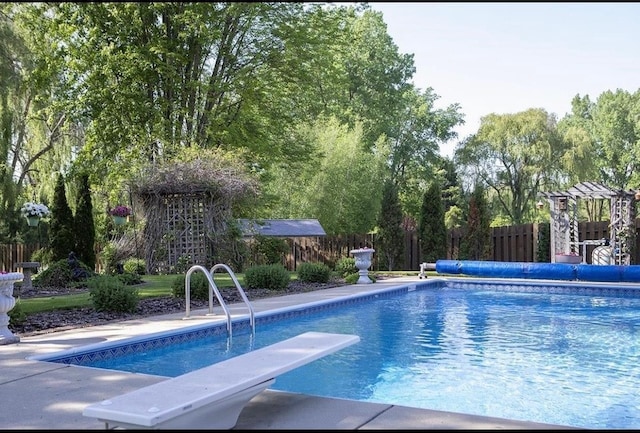 view of pool with a diving board