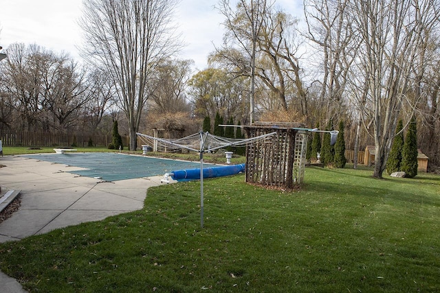 view of swimming pool featuring a patio, a diving board, and a lawn