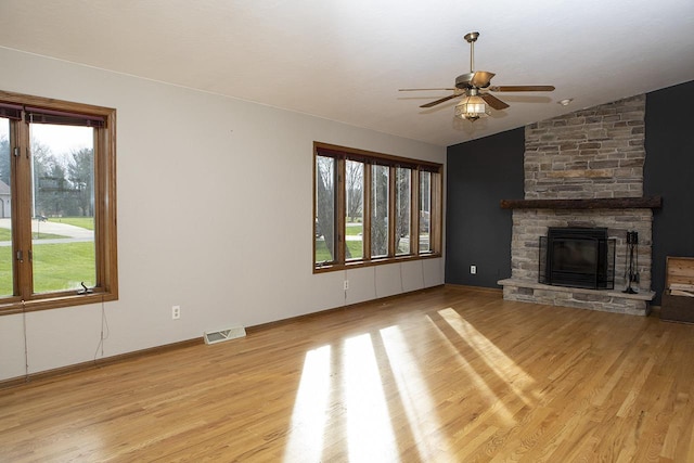 unfurnished living room featuring ceiling fan, lofted ceiling, a fireplace, and light hardwood / wood-style flooring