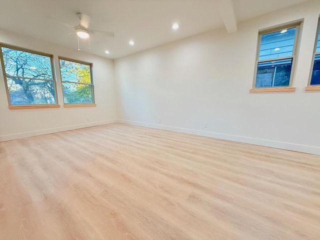 spare room with beam ceiling, ceiling fan, and light hardwood / wood-style flooring