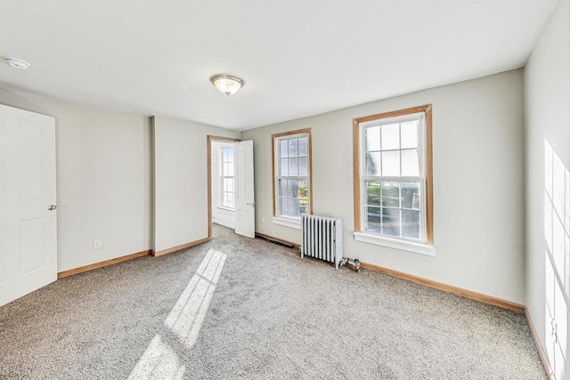 carpeted spare room featuring radiator