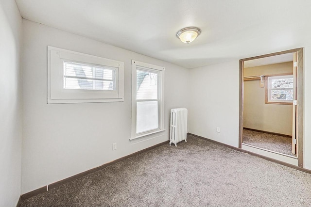 unfurnished bedroom featuring radiator, multiple windows, a closet, and carpet