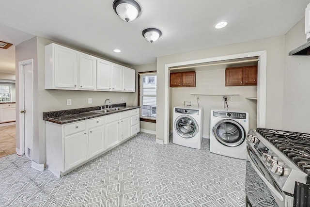 laundry area featuring cabinets, sink, and washing machine and clothes dryer