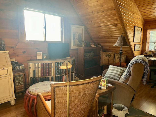 living area with hardwood / wood-style flooring, plenty of natural light, wooden walls, and lofted ceiling