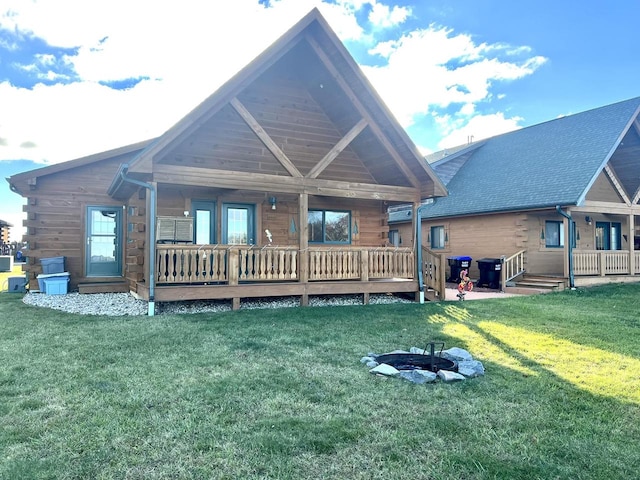 back of house featuring a lawn and a fire pit