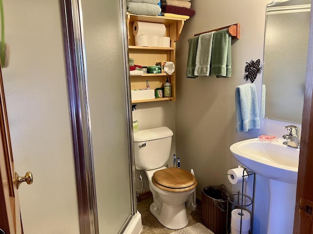 bathroom featuring toilet and a shower with door