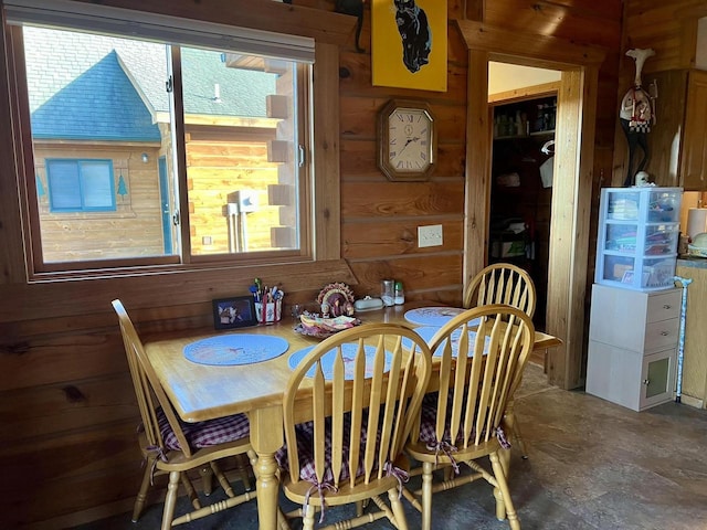 dining area featuring a wealth of natural light and wood walls