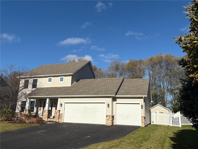 view of front property featuring a garage, a front lawn, and covered porch