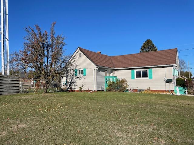 rear view of property with a lawn