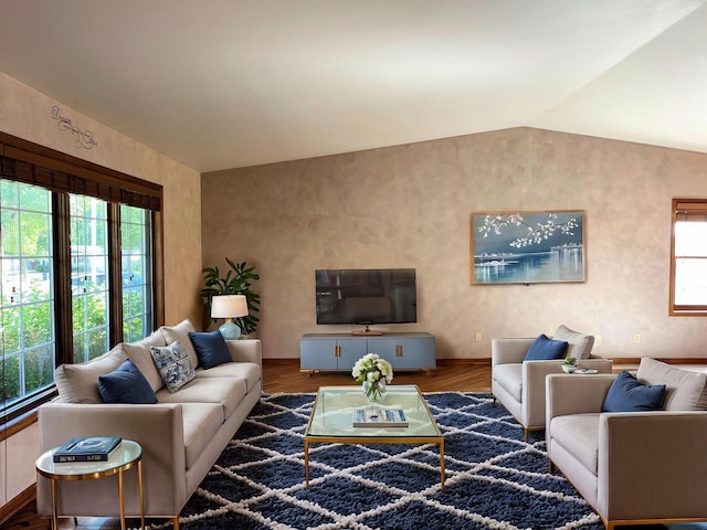 living room with hardwood / wood-style floors, a wealth of natural light, and lofted ceiling