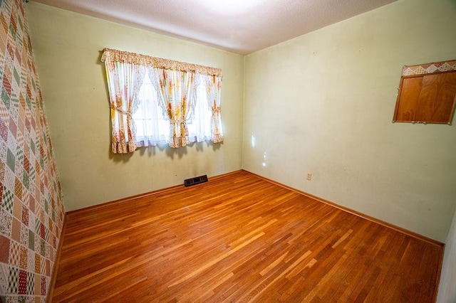 unfurnished room with wood-type flooring