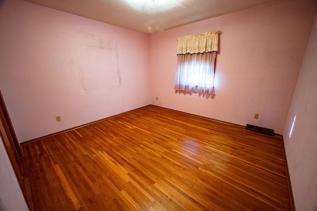 spare room with hardwood / wood-style flooring