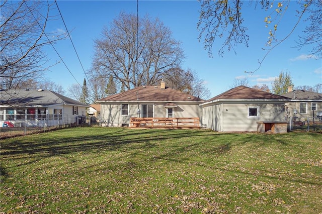 rear view of house featuring a deck and a yard