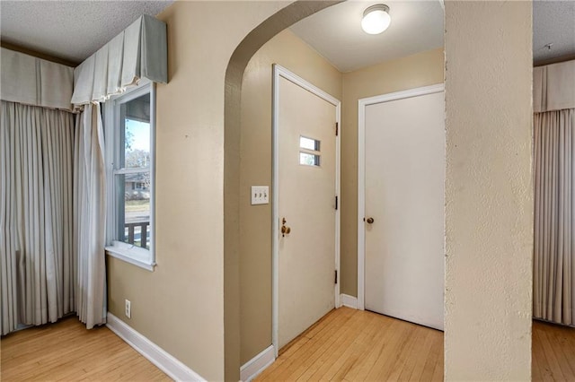 foyer entrance featuring a textured ceiling and light hardwood / wood-style floors