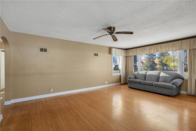 unfurnished living room featuring ceiling fan, a textured ceiling, and light hardwood / wood-style floors