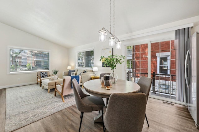 dining space featuring hardwood / wood-style floors and lofted ceiling