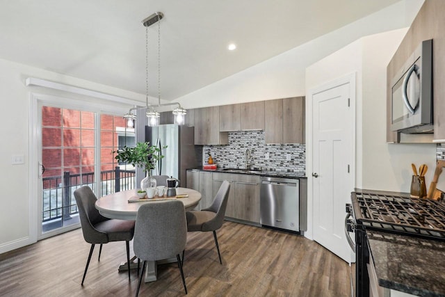 dining area with lofted ceiling, sink, and dark hardwood / wood-style floors